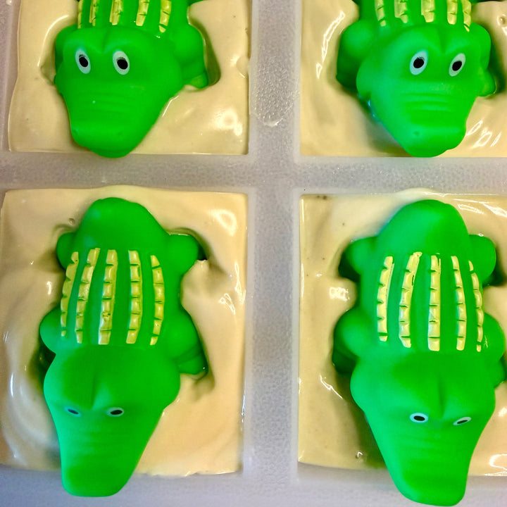 Four green alligator-shaped objects in a grid on a white background