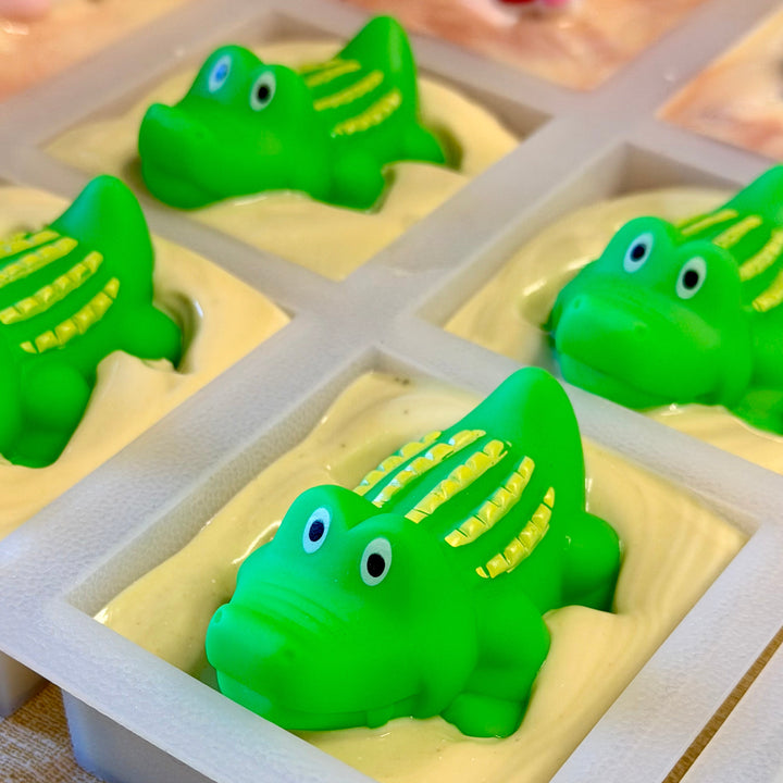 Green rubber duckies in a silicone mold on a textured surface
