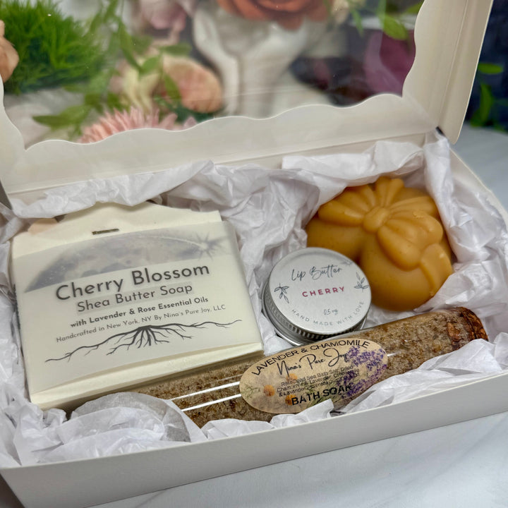 Gift box with Cherry Blossom soap, cherry soap, and other items on a white surface.