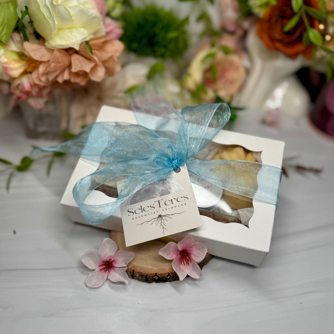 Gift box with blue ribbon and floral decorations on a light surface