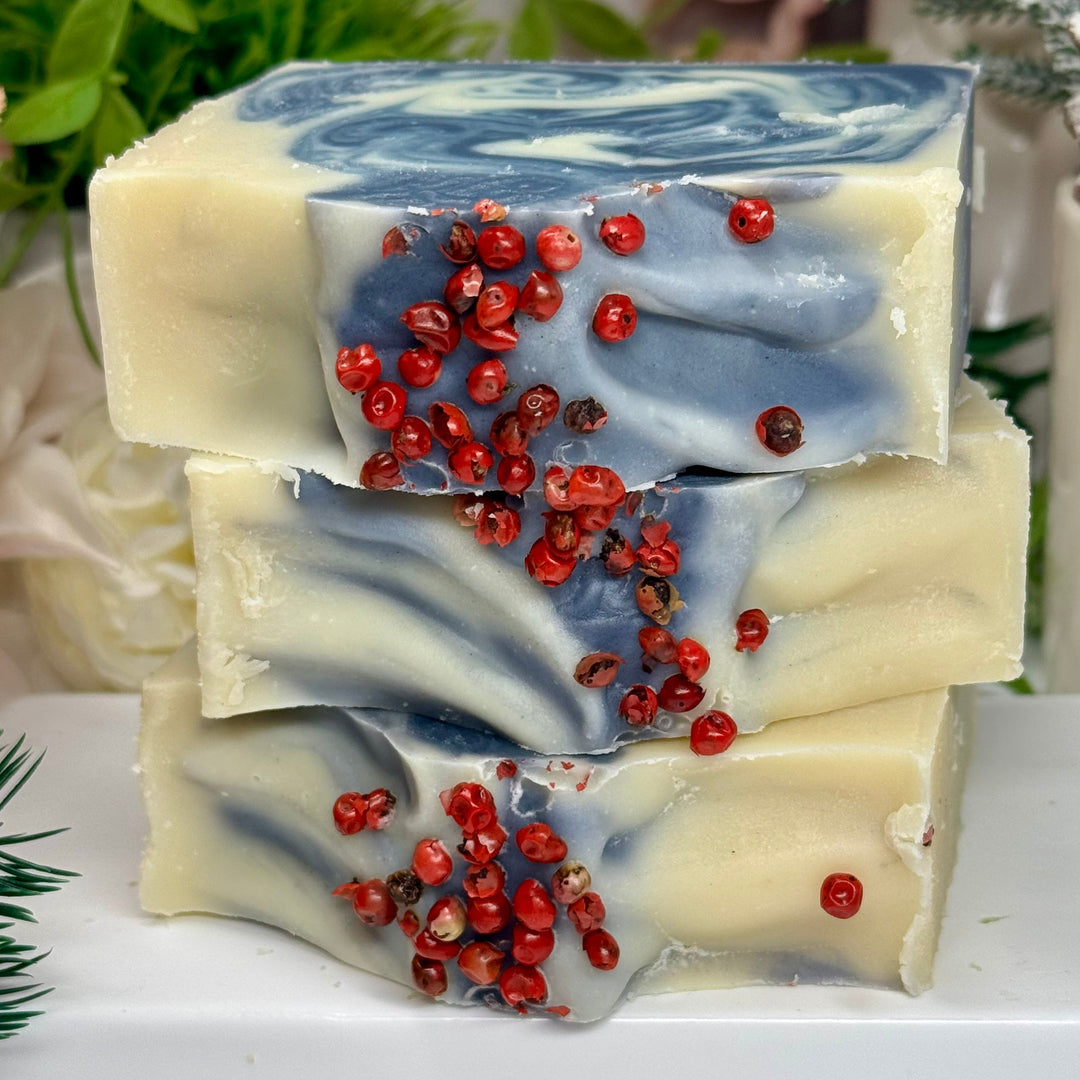 Stack of soap bars with red berries on a white surface