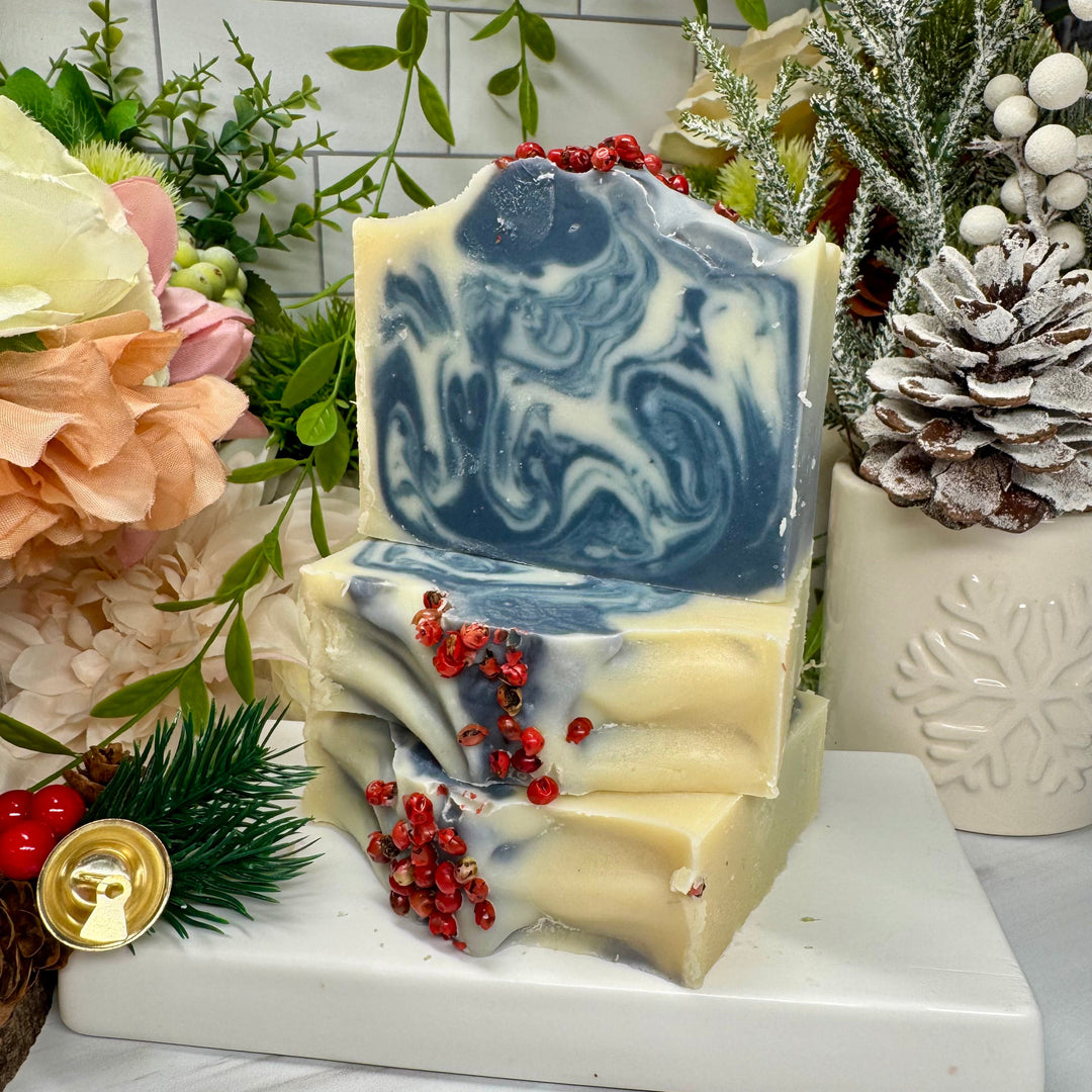 Decorative soap with blue and white swirls on a marble surface with flowers and plants in the background.