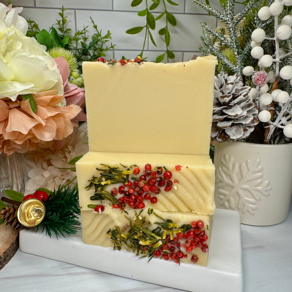 Decorative soap with natural elements on a white marble stand, surrounded by festive decorations.