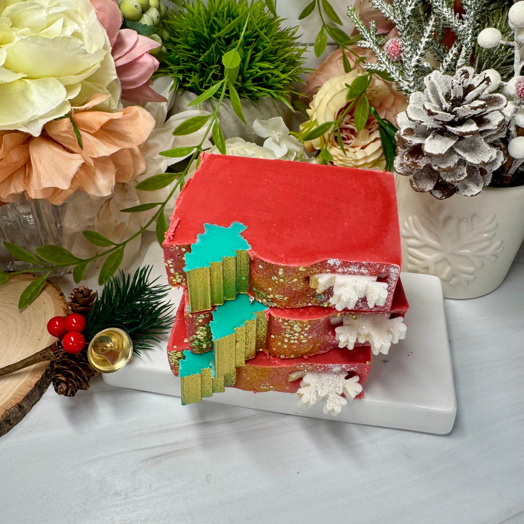 Decorative house model with Christmas elements on a table with flowers and plants.