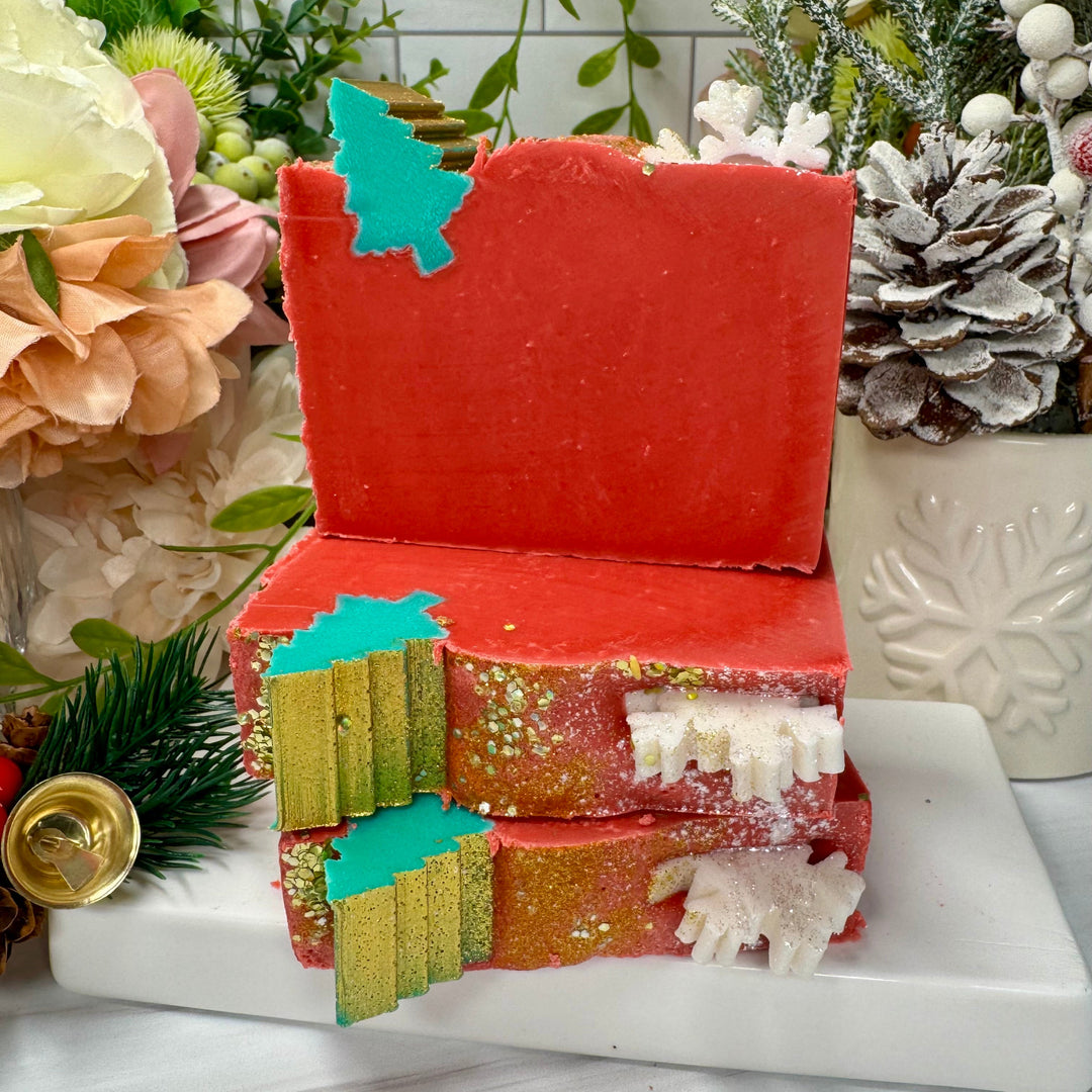 Decorative soap with Christmas design on a white surface with flowers and plants in the background