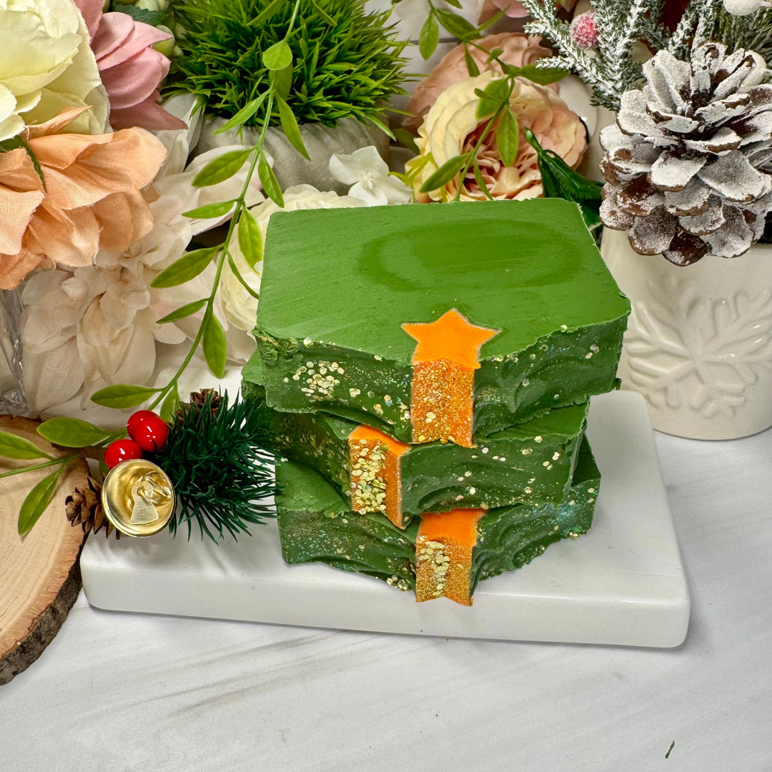 Decorative green soap with gold accents on a white surface with floral and greenery Christmas holiday background