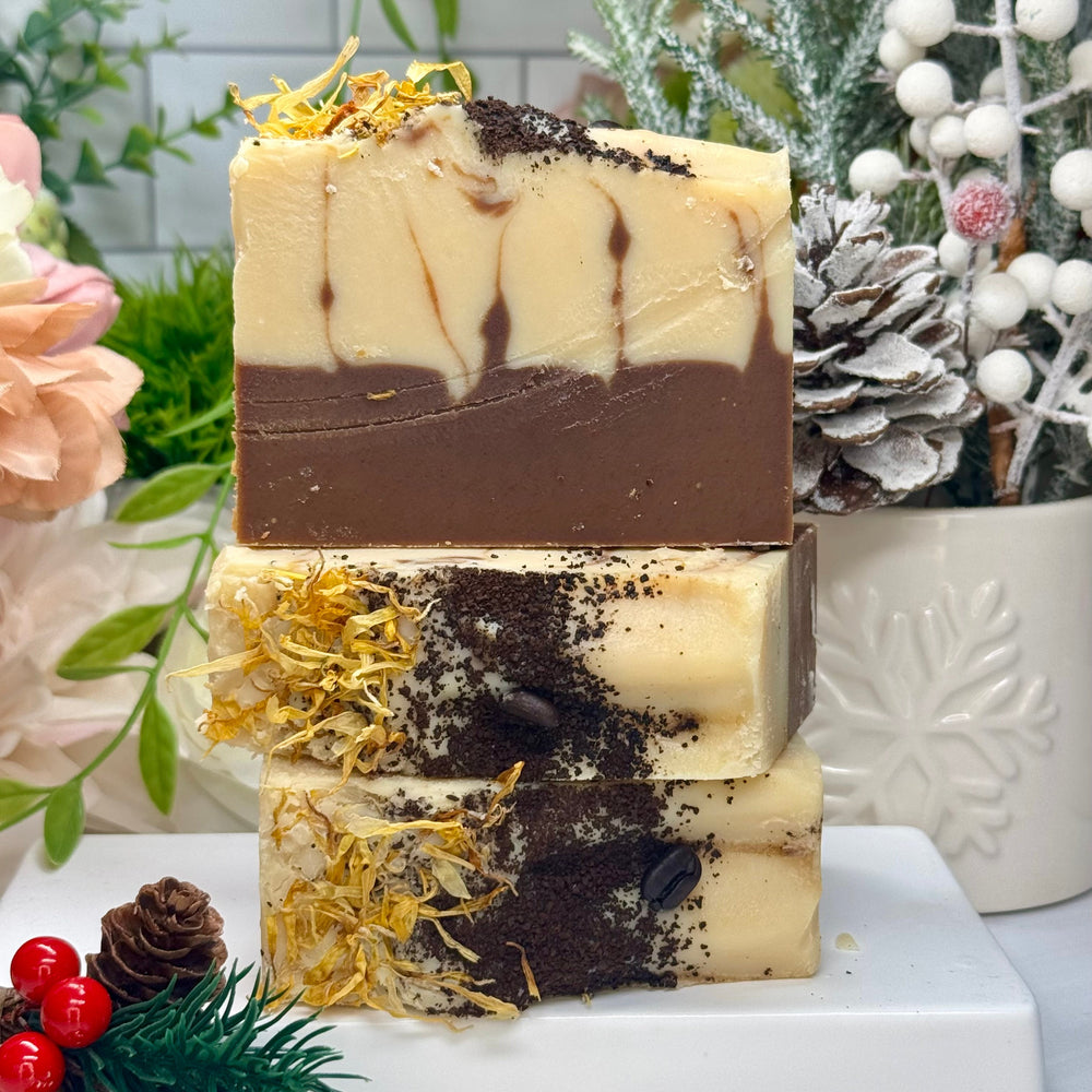 Stack of layered soap bars with decorative elements on a white surface.