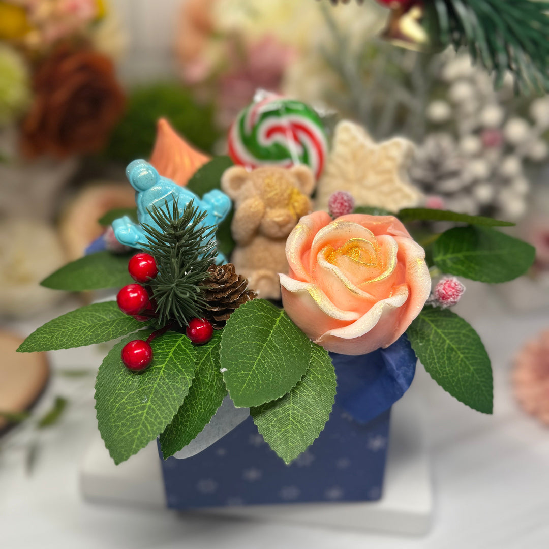 Decorative arrangement with soap flowers, berries, and pinecones on a white surface.